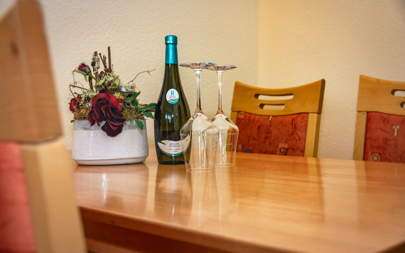 Gästewohnung Radebeuler Str. 6b - Tisch mit Weinflasche, Glässern und Blumen