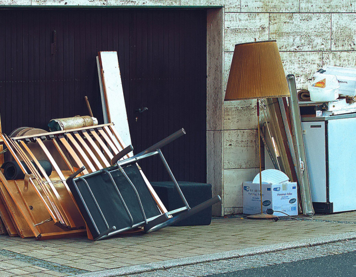 Sperrmüll an einer Hauswand, Lampe, Bett, Schrank usw.